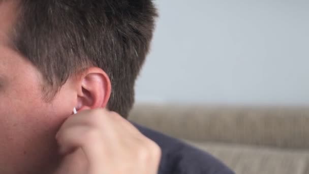 Jeune homme avec un coton-tige nettoie son oreille — Video