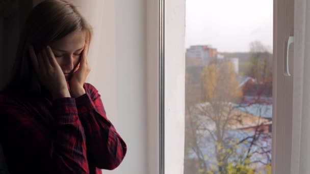 Mooie vrouw wrijft over droge ogen in de buurt van het venster — Stockvideo