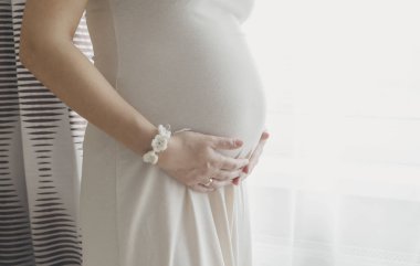 Pencerenin göbek ayakta tutan hamile kadın
