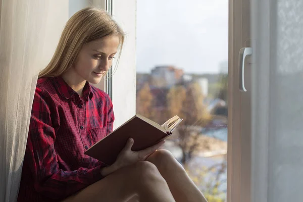 Kadın pencere pervazına eski kitap okuma