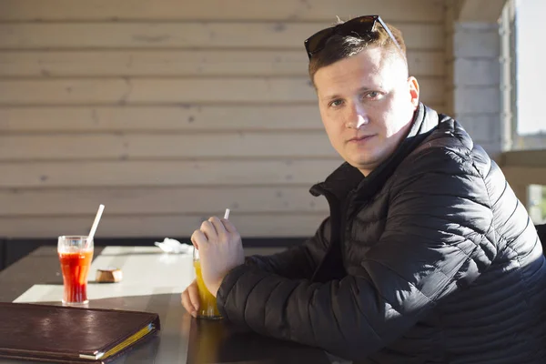 Bardak portakal suyu kameraya bakarak ile genç adam