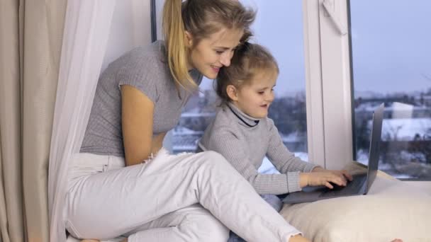Linda chica con su madre usando el ordenador portátil — Vídeos de Stock