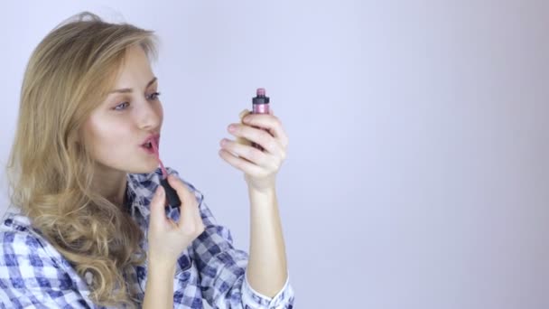 Belle fille modèle peint ses lèvres en regardant petit miroir à la maison — Video