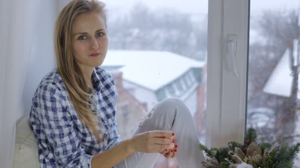 Vrouw tangerine eten en kijken naar de camera — Stockvideo
