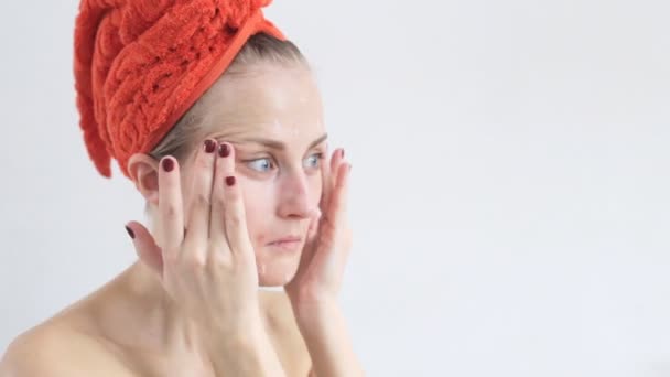 美丽的女人在她的脸上涂抹保湿膏。面子关怀 — 图库视频影像