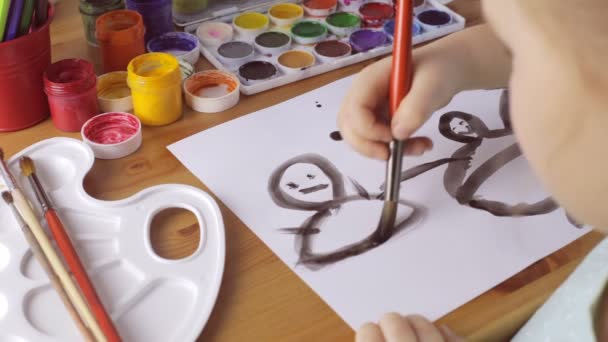 Young sad girl draws people with black paints — Stock Video