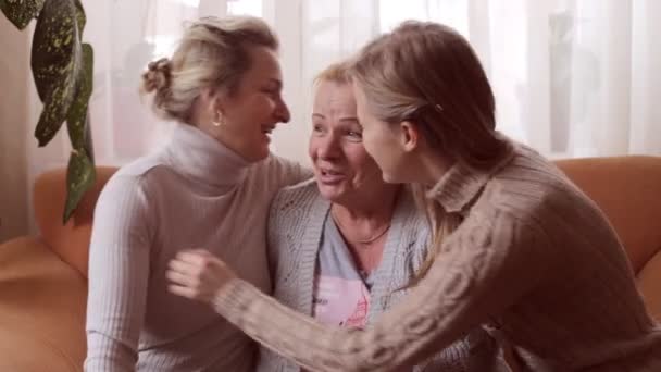 Daughter and granddaughter kiss their grandmother. Happy family concept — Stock Video