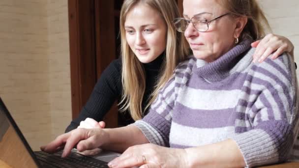 Granddaughter teaches her grandmother to work on a laptop — Stock Video