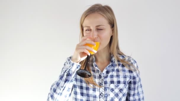 Menina saudável bebe suco de laranja. Jovem com um copo de suco — Vídeo de Stock