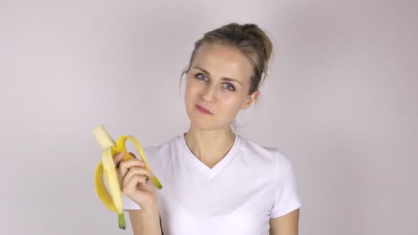 Hermosa joven come plátano y muestra el pulgar hacia arriba. Primer plano — Vídeos de Stock