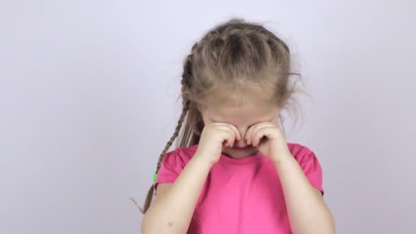 Mladá dívka v růžové košili, mnula si oči — Stock video
