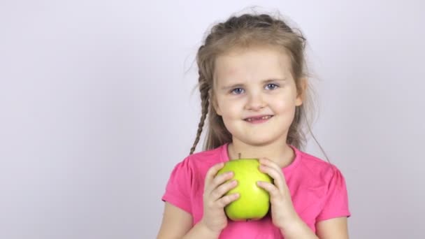 Una joven sostiene una gran manzana verde — Vídeos de Stock