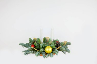 Ladin 'in Noel kompozisyonu, beyaz arka planda mumlar.