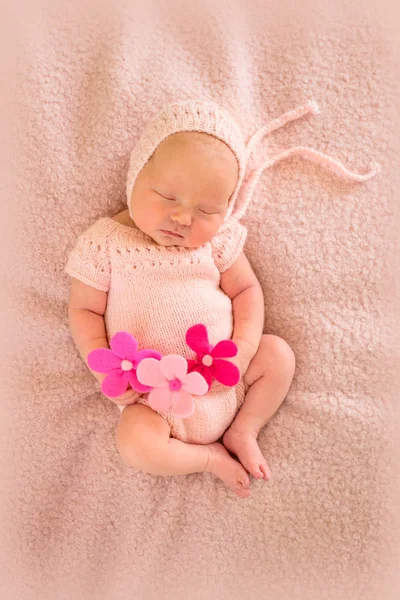 Portrait of a newborn sleeping baby with pink flowers — Stock Photo, Image