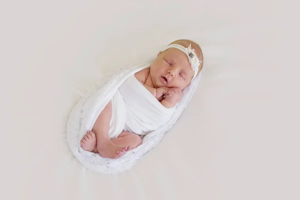 Pequeño recién nacido en una envoltura blanca está durmiendo dulcemente —  Fotos de Stock