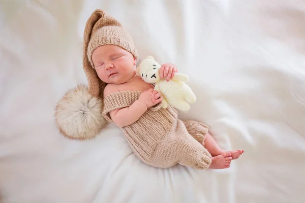 Bebé recién nacido en un traje de punto en una pose hermosa miente —  Fotos de Stock