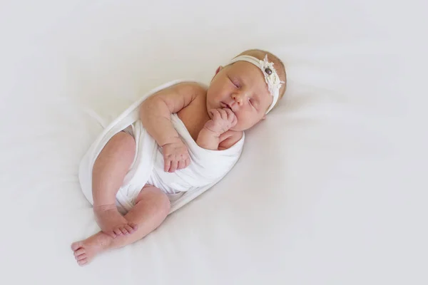 Una niña recién nacida en una envoltura blanca está durmiendo dulcemente —  Fotos de Stock