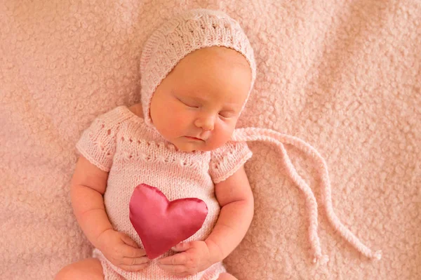 Elinde ipek bir kalple uyuyan bir bebeğin portresi.