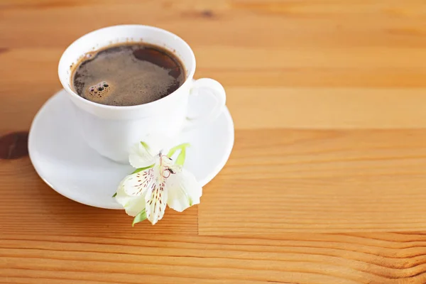 Cup of fresh morning coffee with a flower on a plate