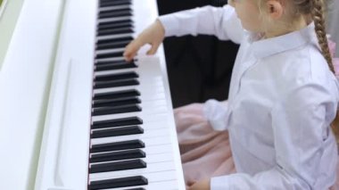 Little girl studying music on the piano