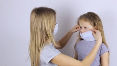 Anne kızına koruyucu bir maske takıyor.