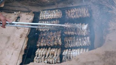 İn-yer Barbekü ızgara ve pişirme maşa kullanarak balık (yakın )