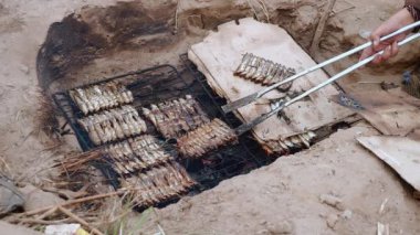 İn-yer Barbekü ızgara ve pişirme maşa kullanarak balık (yakın )