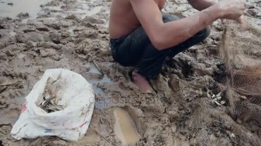 Enmeshed balık onun net kaldırma ve bir plastik torba içinde tutarak balıkçı