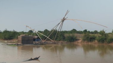 Bambu balık sandık düşük tide nehirde çıkan; Çince balık ağı arkasında ile ev Tekne