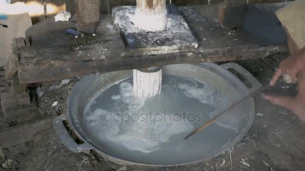 Hombre presionando masa de arroz; Fideos de arroz se cocinan en agua hirviendo inmediatamente — Vídeos de Stock