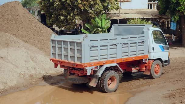 Camion in retromarcia presso il sito di smaltimento per la sabbia dragata del fiume e un escavatore carico di sabbia in un camion — Video Stock