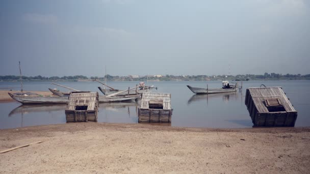 Κιβώτια ξύλινα ψάρια δίπλα σε μικρά αλιευτικά σκάφη στην άκρη του ποταμού (κοντινό πλάνο) — Αρχείο Βίντεο