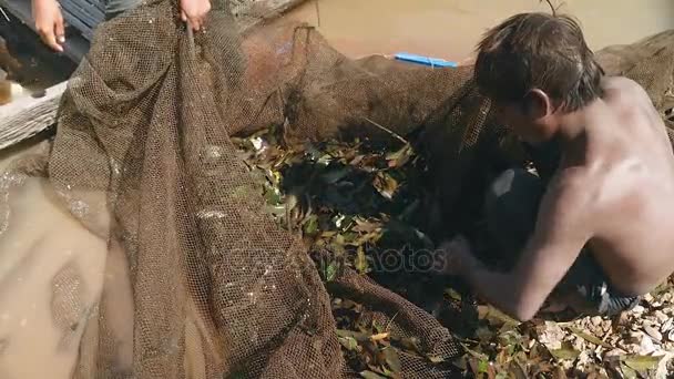 Vissers (vrouw en man) het verzamelen van vis vangsten in het visnet — Stockvideo