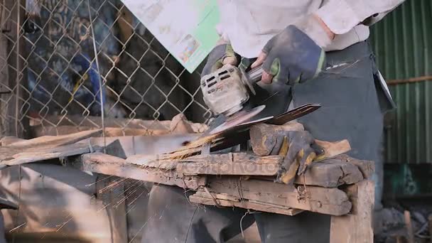 Worker sharpening a traditional broad blade with a grinding wheel — Stock Video