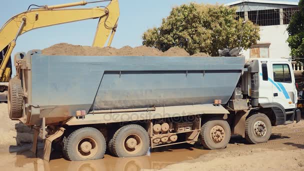 Excavadora cargando arena en un camión volquete — Vídeo de stock