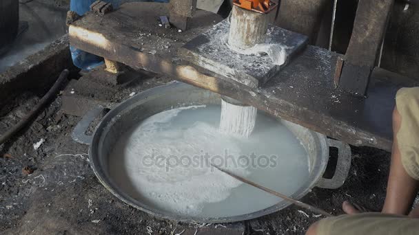 Los fideos de arroz caen directamente en agua hirviendo para cocinar y el hombre saca la máquina del estante después de presionar — Vídeos de Stock