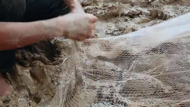 Pescador sacando pescado enredado de su red y guardarlo en una bolsa de plástico — Vídeos de Stock