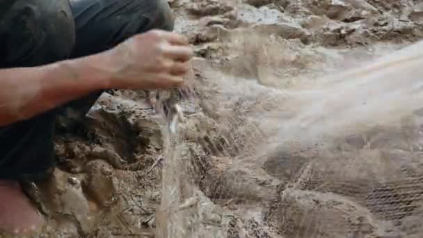 Pescador sacando pescado enredado de su red y guardarlo en una bolsa de plástico — Vídeos de Stock