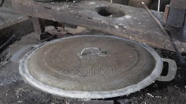 Close-up on covered pot with boiling water over in-ground fire pit for the making of rice noodles — Stock Video