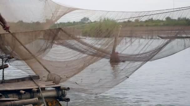 Vista del nivel del agua de la red de pesca de río chino y el pescador que utiliza una red de mano para capturar peces fuera de ella — Vídeo de stock