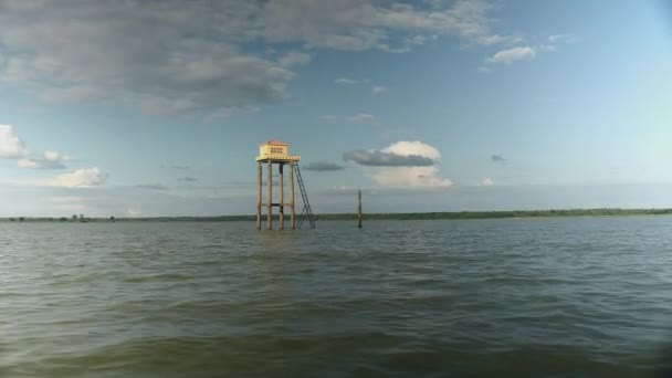 Pequeno templo budista empoleirado em palafitas no meio de um lago — Vídeo de Stock