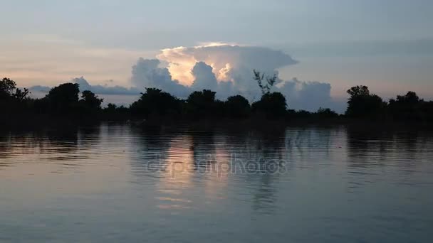Vista de uma pequena lancha durante um passeio em um lago com formação de nuvens contra o pôr do sol — Vídeo de Stock