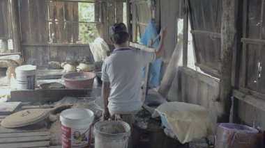 pirinç hamur (arkadan görünüm şeritler halinde kesmek için presleme makinesi kullanan adam)