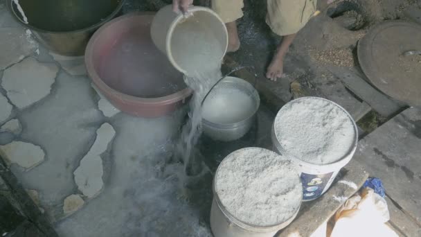 Primer plano en un hombre ablandando fideos de arroz con agua en un cubo hueco antes de quitarlo — Vídeos de Stock