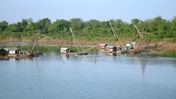 Casas flotantes y redes de pesca chinas en el río; Pescador levantando la red de pesca china fuera del agua — Vídeo de stock