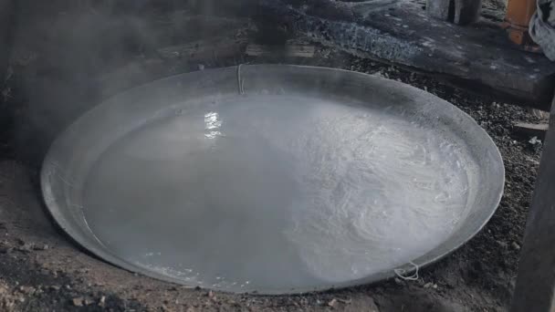 Primo piano su acqua bollente in una bacinella d'acciaio per cucinare tagliatelle di riso — Video Stock
