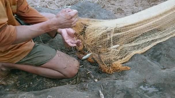 Fisherman untangling fishing net and removing woody debris ( close up) — Stock Video