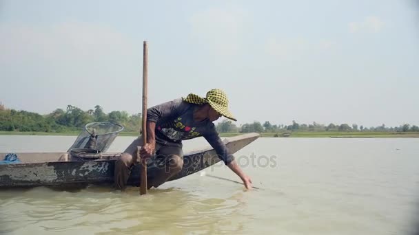 Человек на лодке в грязной реке — стоковое видео
