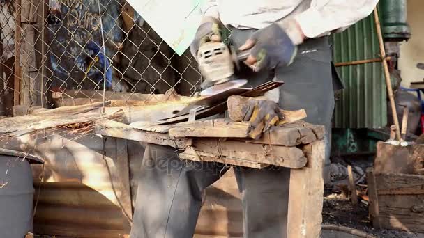 粉砕車輪で伝統的な広い刃を研ぎ出す労働者 — ストック動画