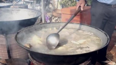 Tavuklar büyük bir açık wok pişirme kaynama